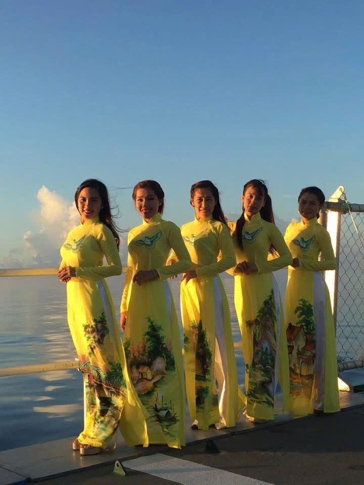 Dancers in yellow áo dài at sunset